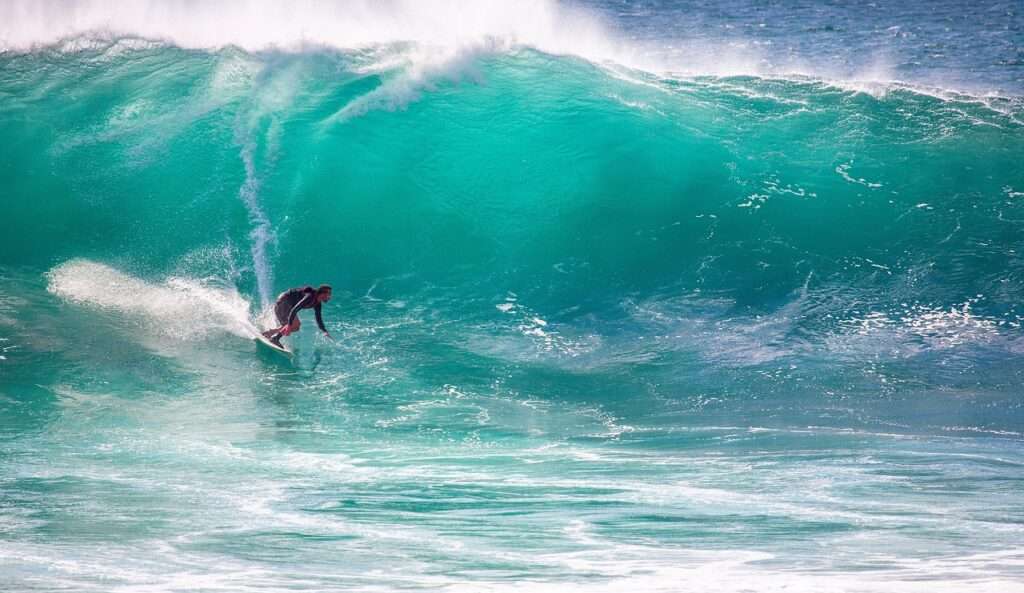 Surfer auf riesiger Welle: Schicksal als Chance? Buch-Tipp zu Thorwald Dethlefsen. Wagemutiger Sportler bezwingt die Naturgewalt.